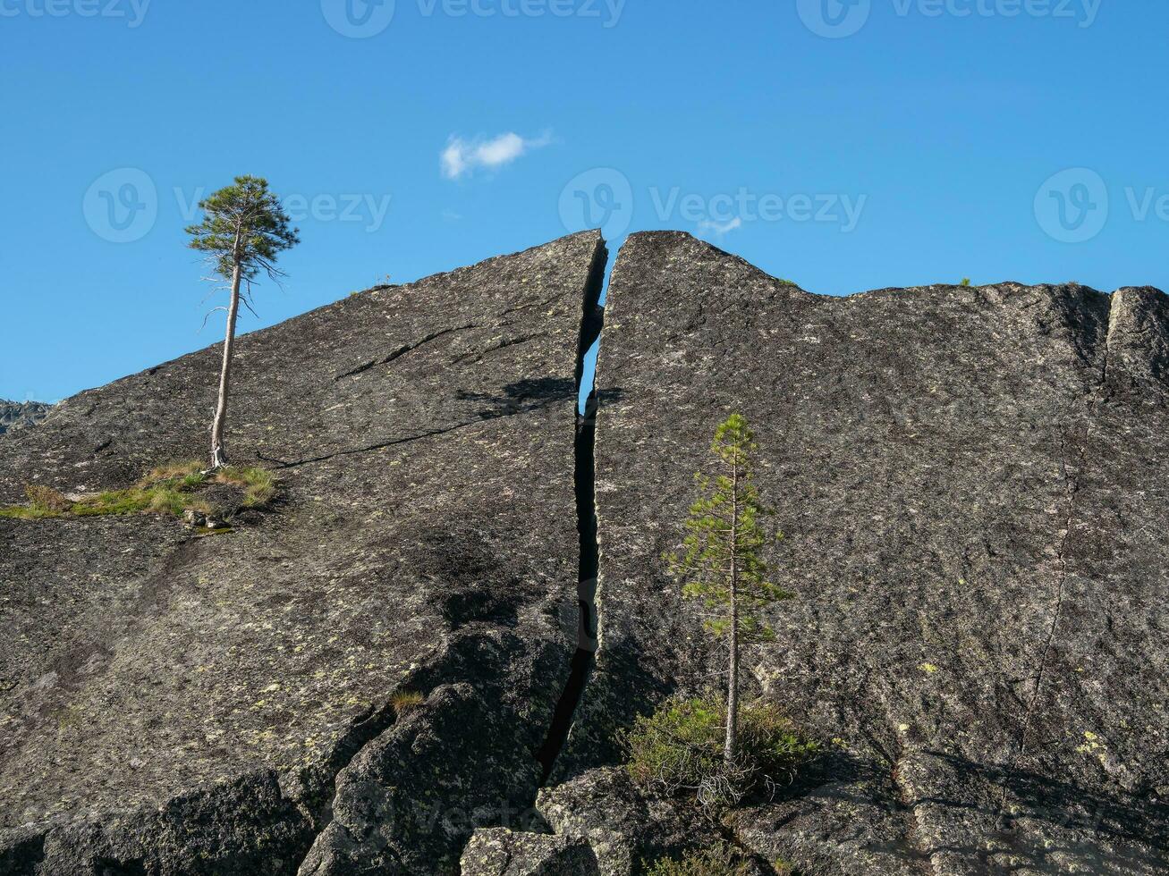 Huge granite boulder is split in half. The crack in the granite monolith. photo