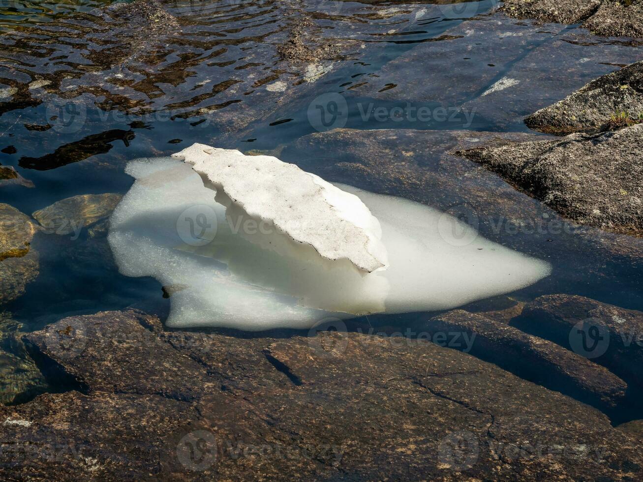 Impressive ice floe melts on a mountain lake. White iceberg on the blue water. Natural background. photo