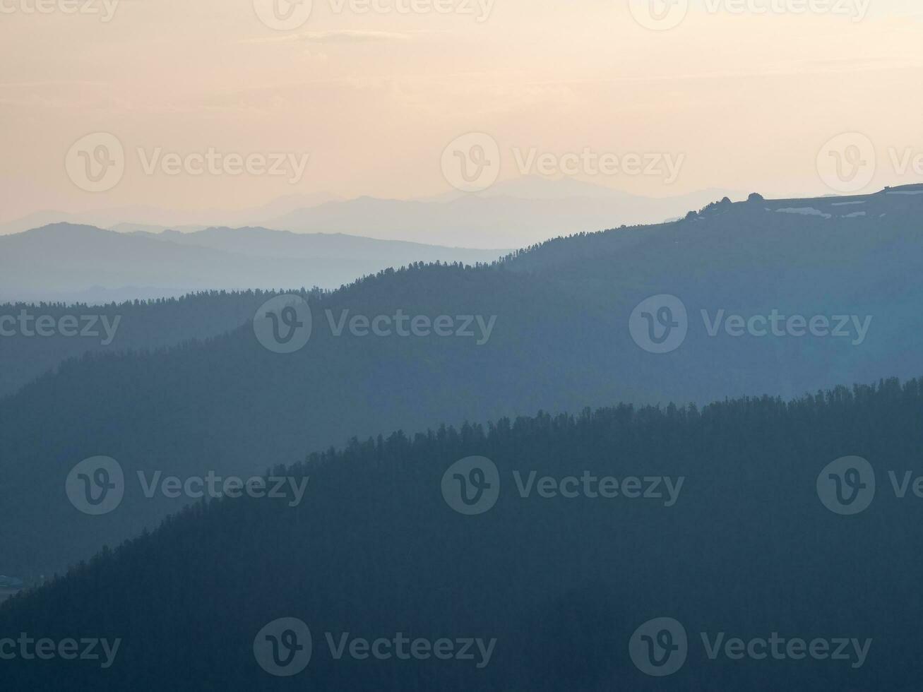 Layers of mountains at sunset. Soft pink sunset in mountain landscape. Amazing pink sunset with a silhouette of mountains. photo