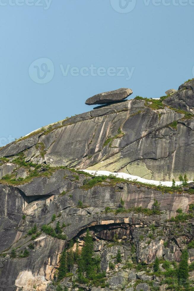 Falling large boulder on the edge of the abyss. Midday view, Western Sayan. Natural Park Ergaki. Krasnoyarsk region. Vertical view. photo