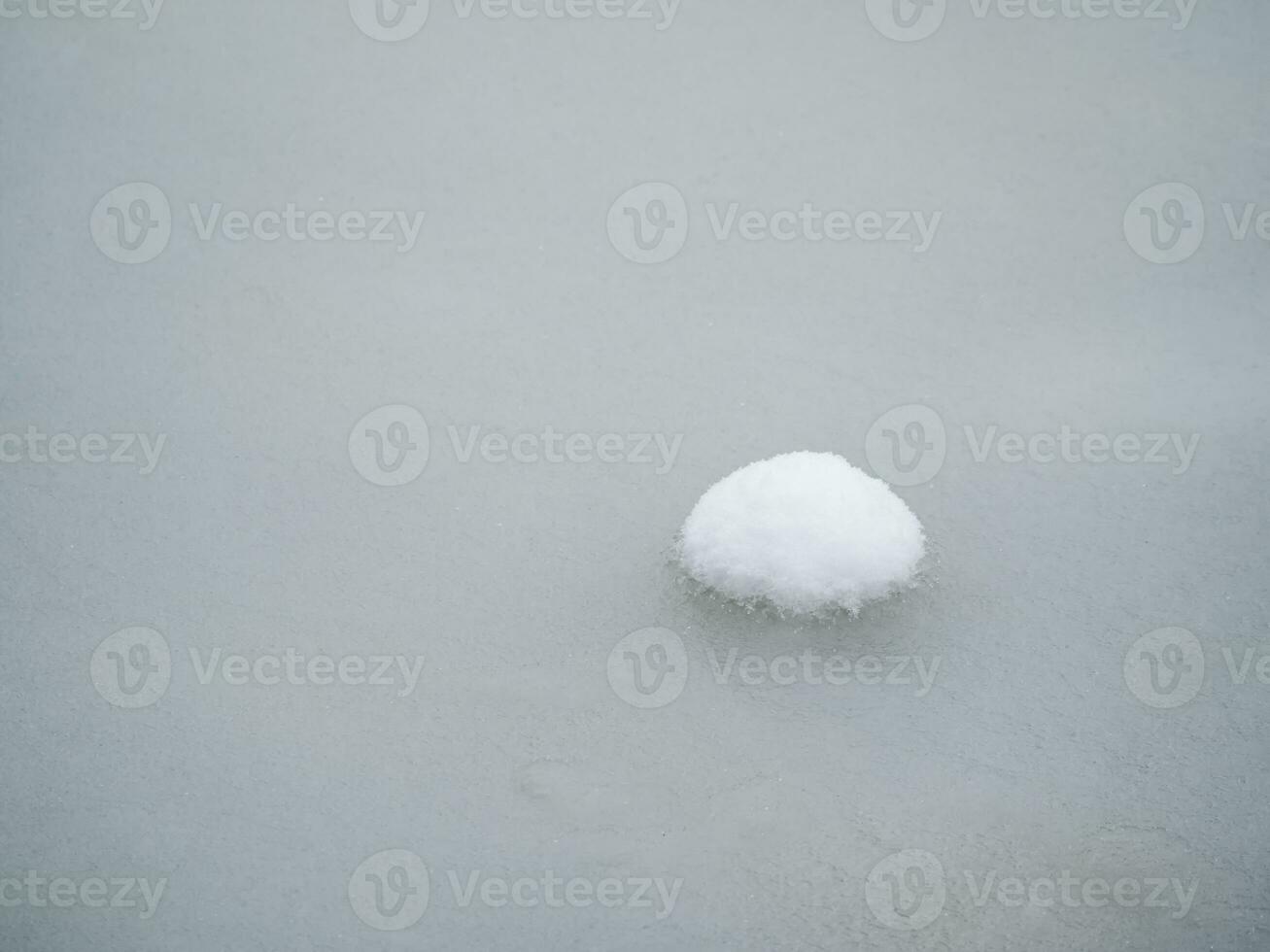 Selective focus. Spring ice, small snowy round island on melting ice. Abstract natural background. photo