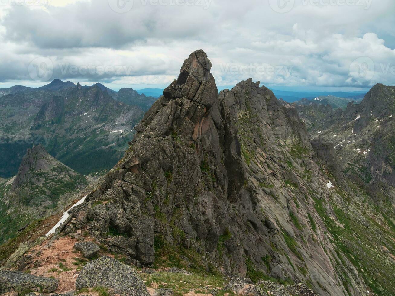 puntiagudo acantilado, un brumoso ladera de la montaña fantasma rocas increíble escénico montaña paisaje con grande agrietado puntiagudo piedras de cerca en brumoso Mañana. agudo rocas antecedentes. occidental sayanos foto