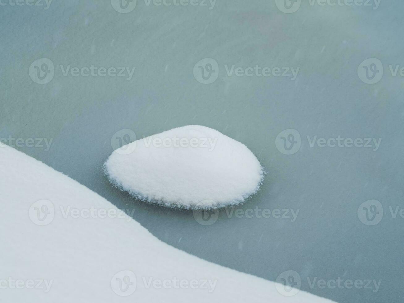 Selective focus. Spring ice, small snowy round island on melting ice. Abstract natural background. photo