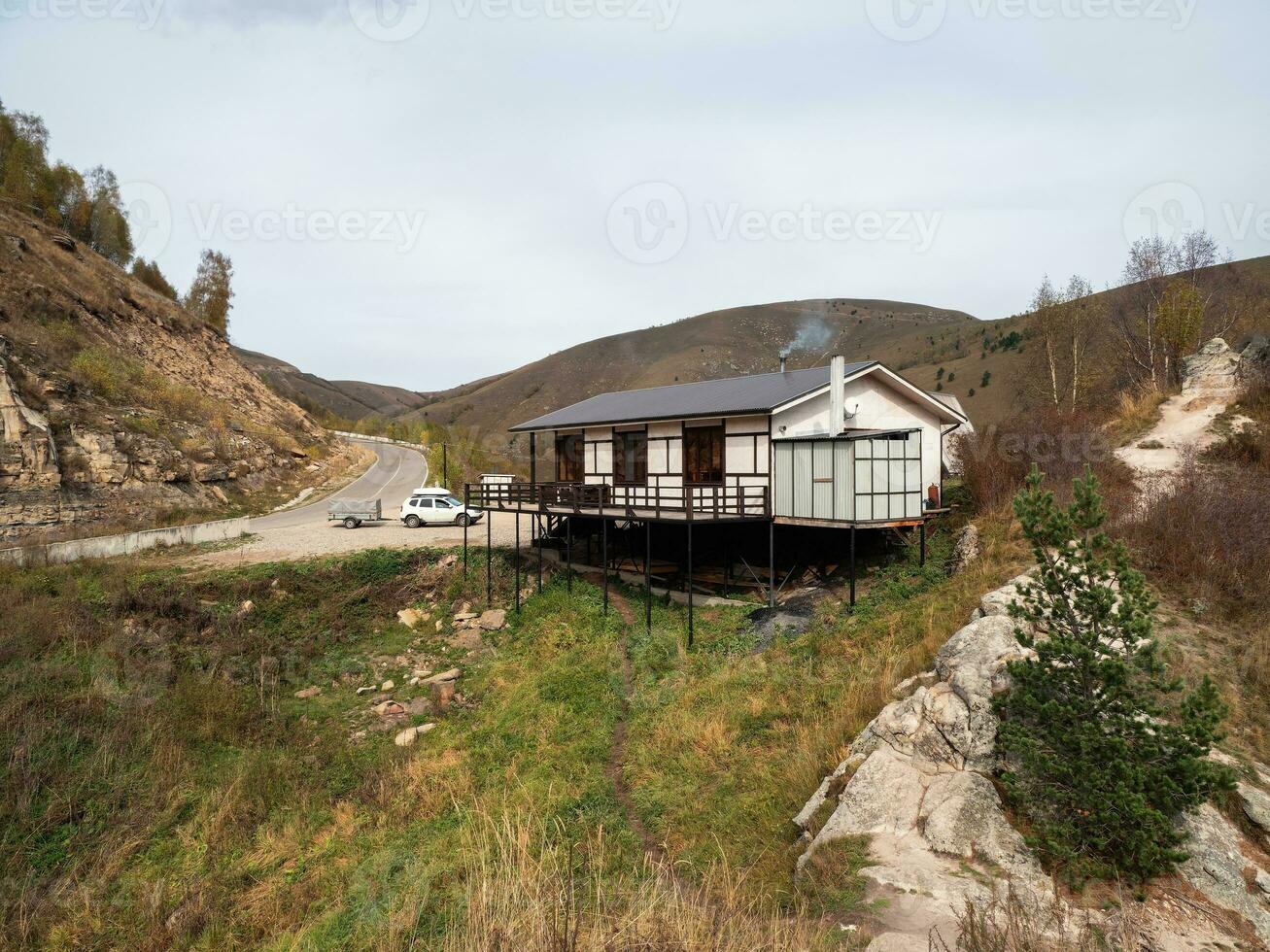 Wooden roadside cafe on a mountain highway. Smoke from a chimney on the roof of a roadside restaurant. Karachay-Cherkessia. photo