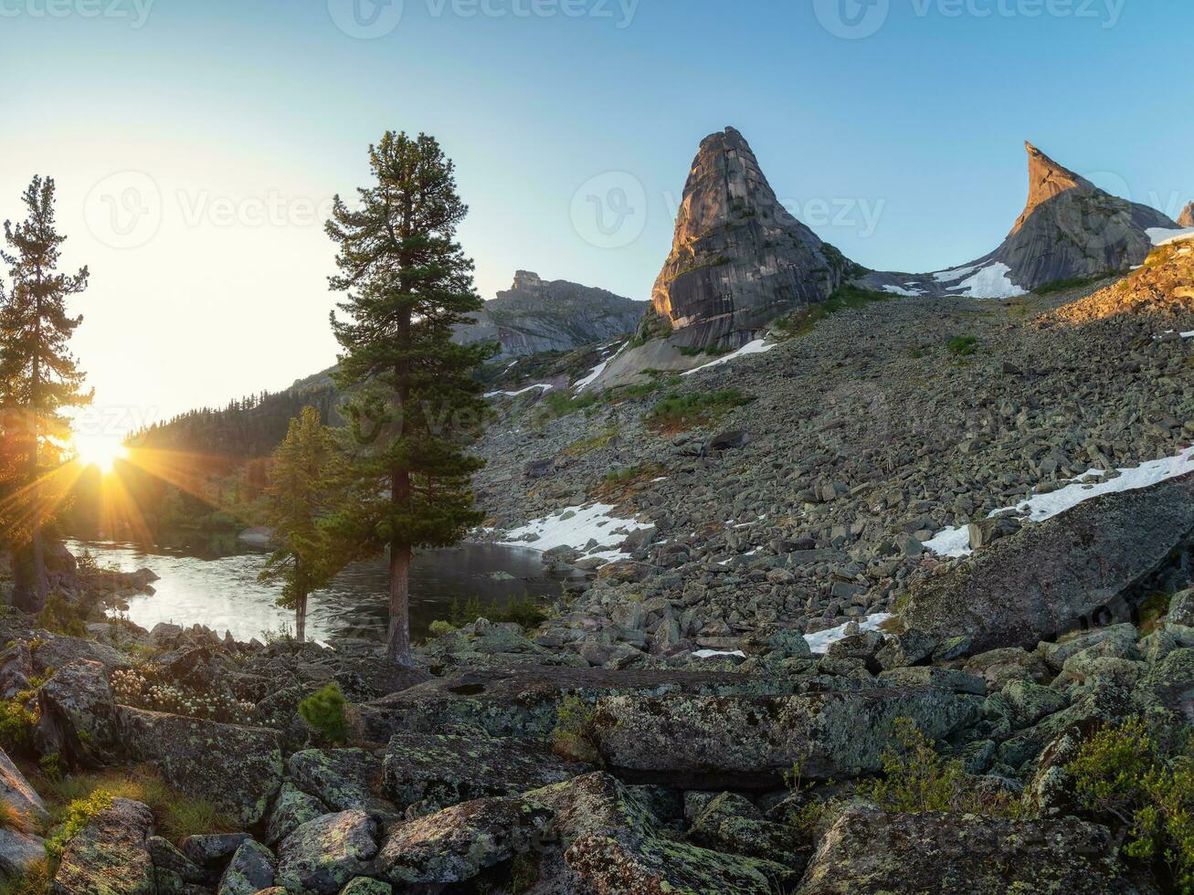 Beautiful landscape with high  mountains with illuminated peaks, stones in mountain lake, reflection, blue sky and yellow sunlight in sunrise. Ergaki. Amazing scene with West Sayan mountains. photo