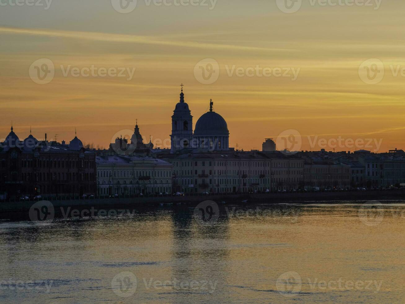 Golden spring sunset in city. Saint Petersburg cityscape over Neva River in Russia. City skyline colorful photo with historical Russian architecture. Postcard view of the city.