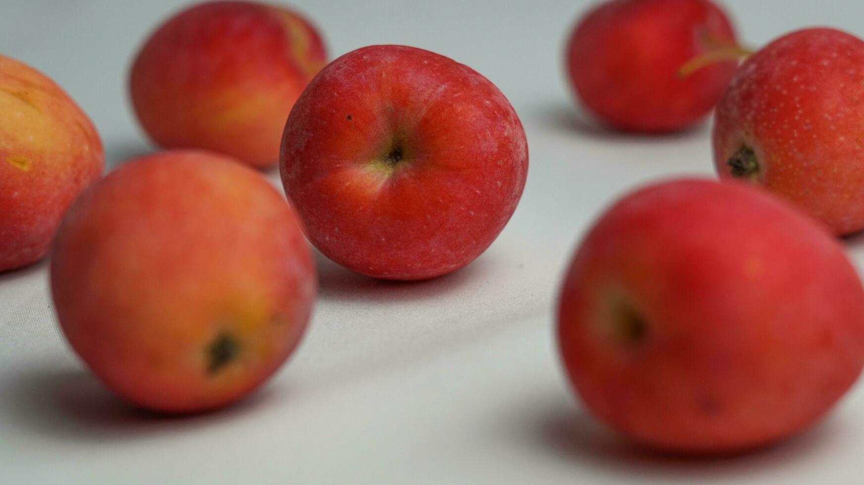 This fruit is called a strawberry apple, it tastes like an apple with a shape like a strawberry photo