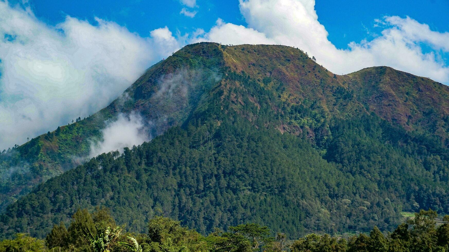 view of mountains with white clouds in the sky photo