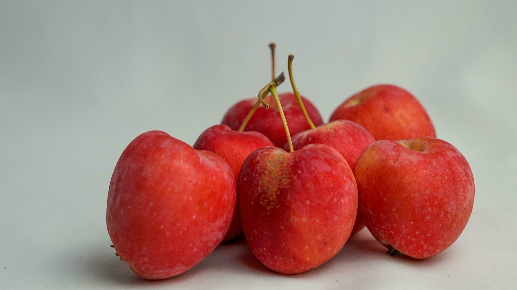 This fruit is called a strawberry apple, it tastes like an apple with a shape like a strawberry photo