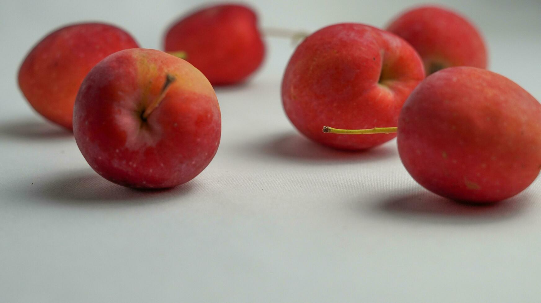 This fruit is called a strawberry apple, it tastes like an apple with a shape like a strawberry photo