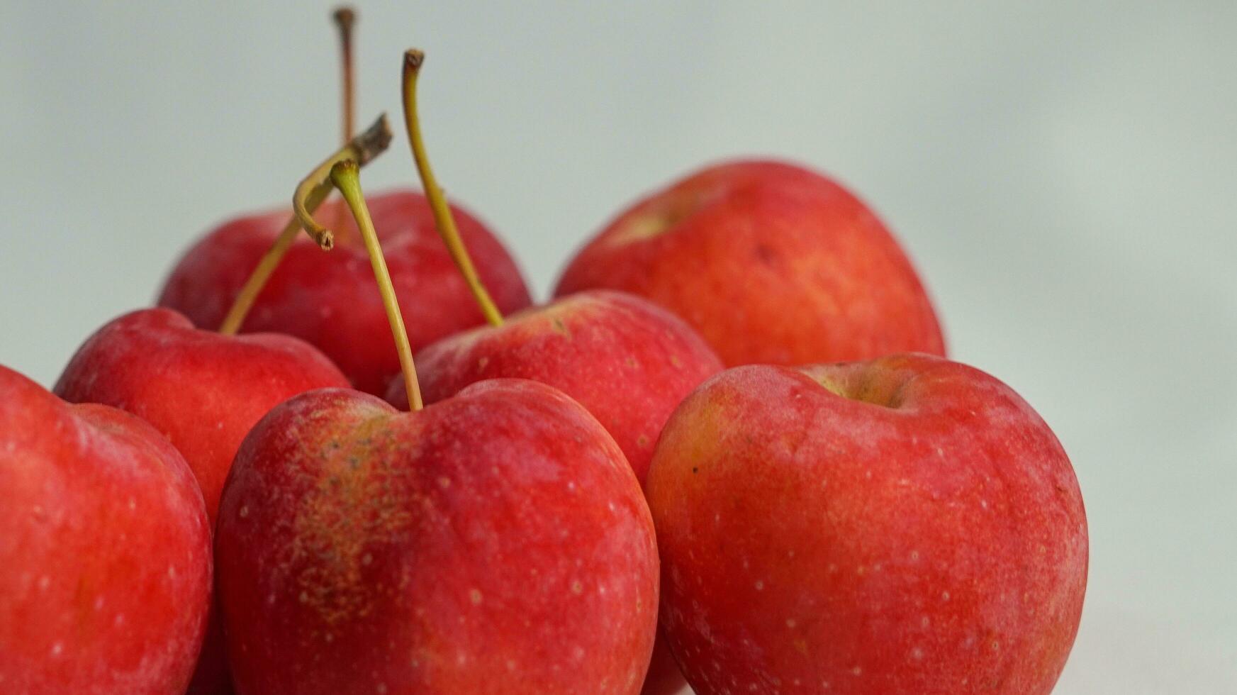 This fruit is called a strawberry apple, it tastes like an apple with a shape like a strawberry photo