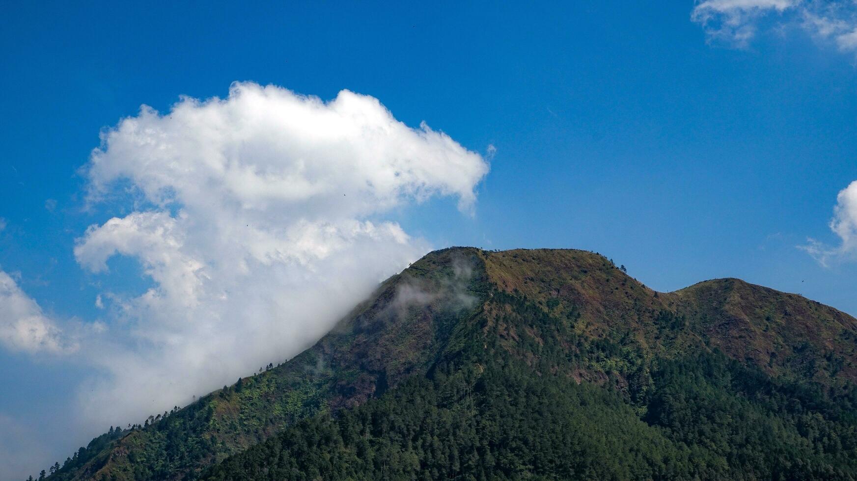 view of mountains with white clouds in the sky photo