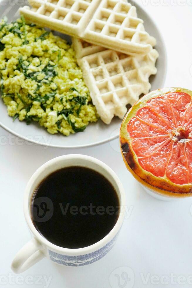 Breakfast with coffee, waffles and orange on a white backgroundBreakfast with coffee, waffles and orange on a white background photo