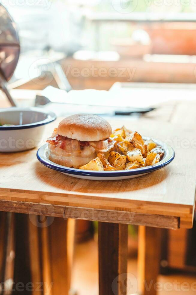 Hamburger with french fries on wooden table in cafe, stock photo