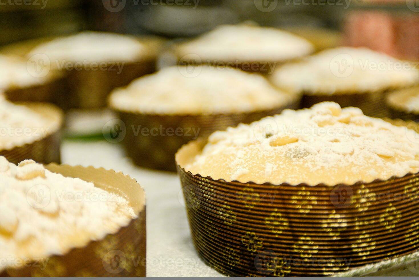 chef producing panettone, while lievitate, adding almond sugar topping to raw sweet bread. photo