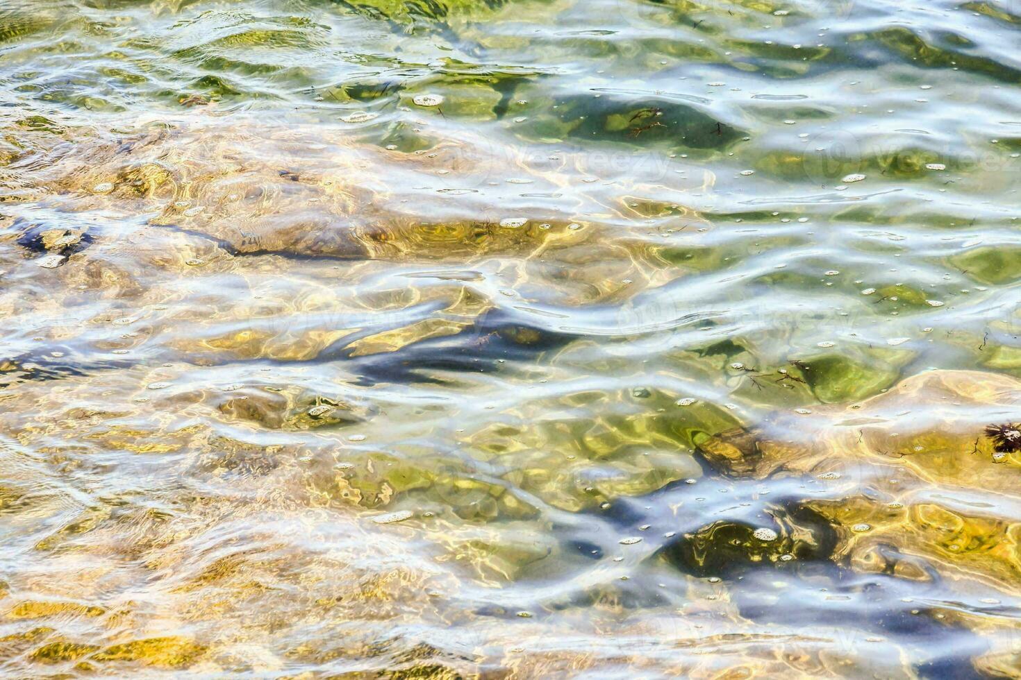 Clear water with rocks underneath photo