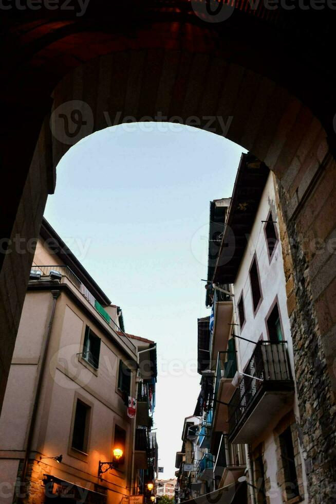 un estrecho calle con un Roca arco foto