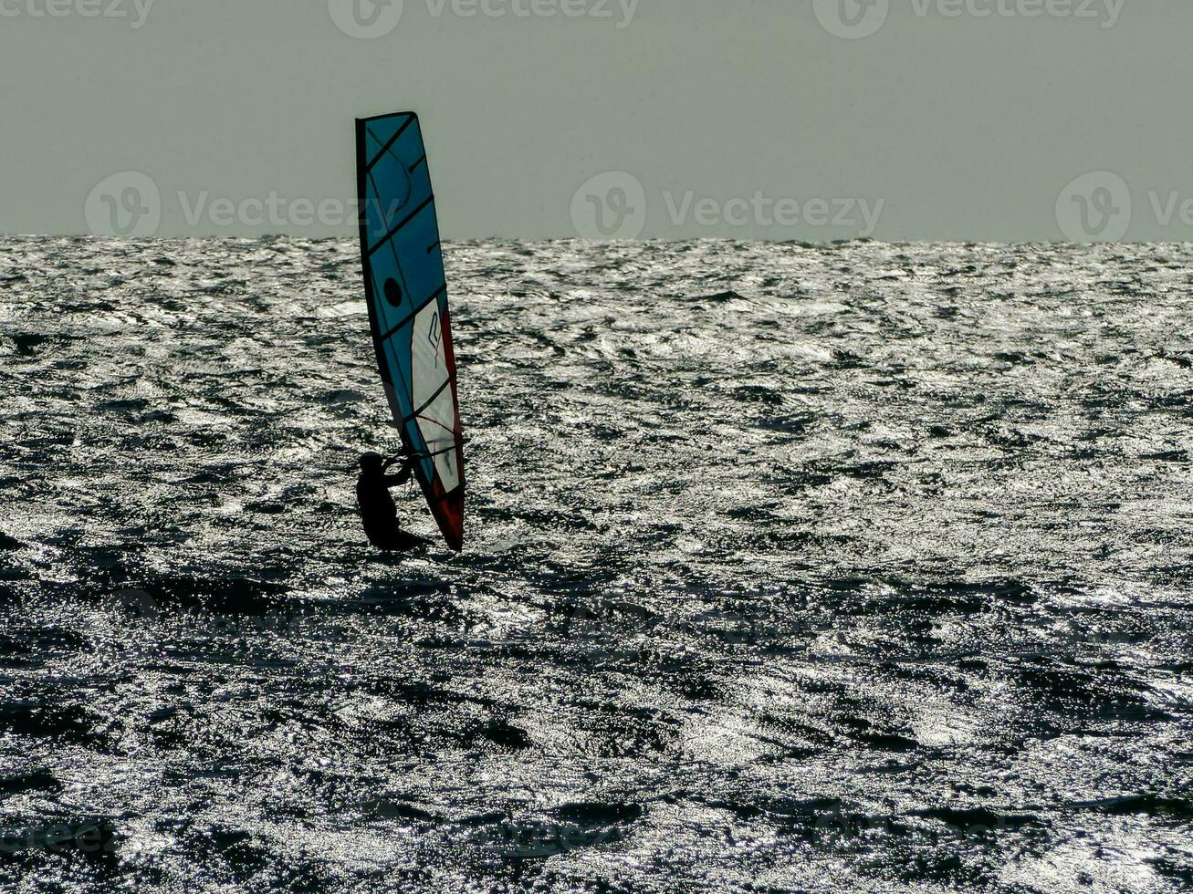 a person windsurfing in the ocean photo