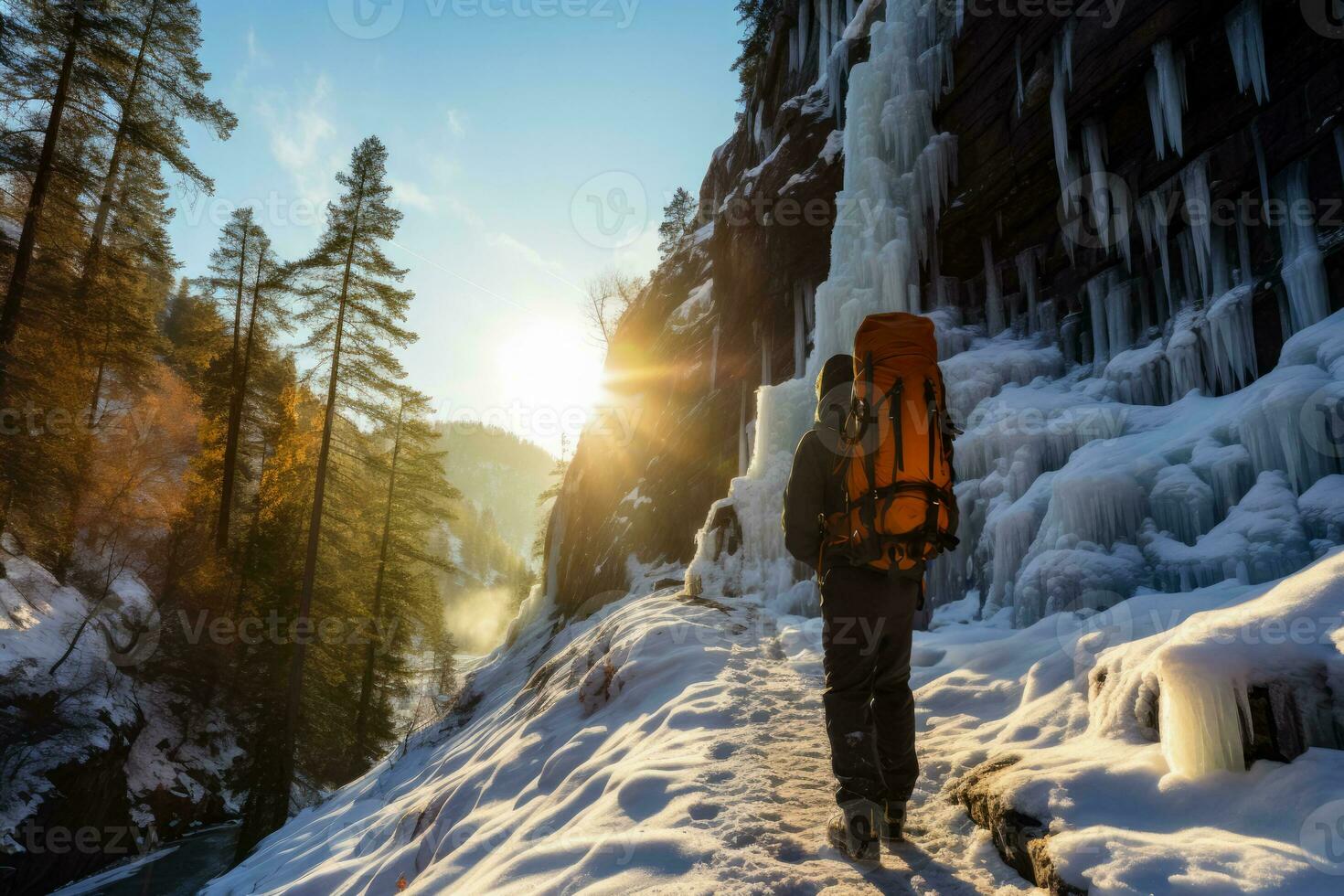 Climber gracefully navigates sunlight dappled frozen waterfall in wintry wilderness photo