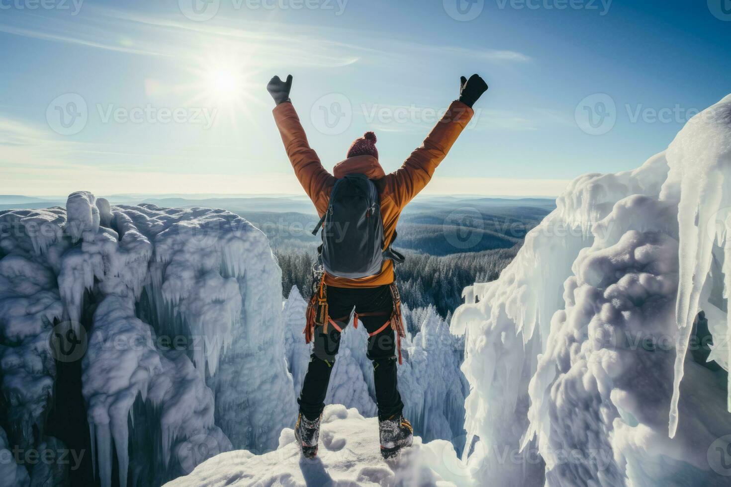 Triumphant climber atop frozen waterfall background with empty space for text photo