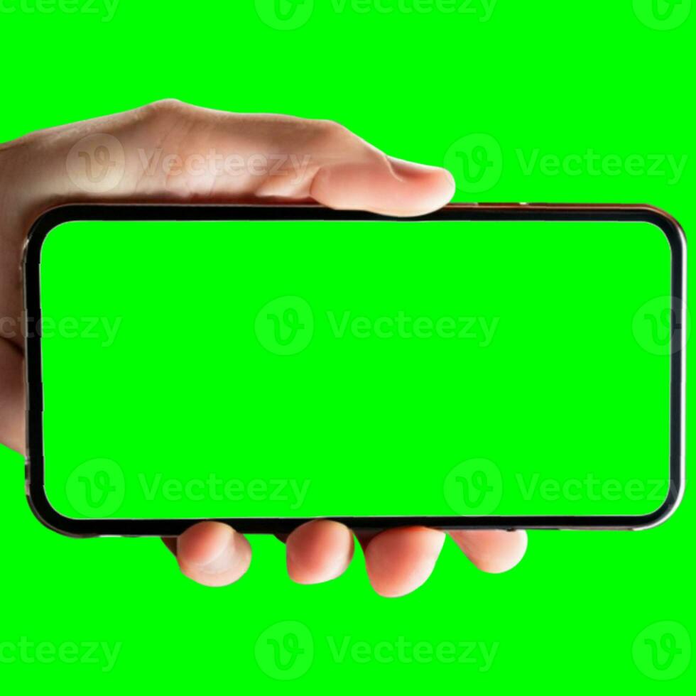 Image of hand holding a phone with a green screen in landscape orientation. on a white background. photo