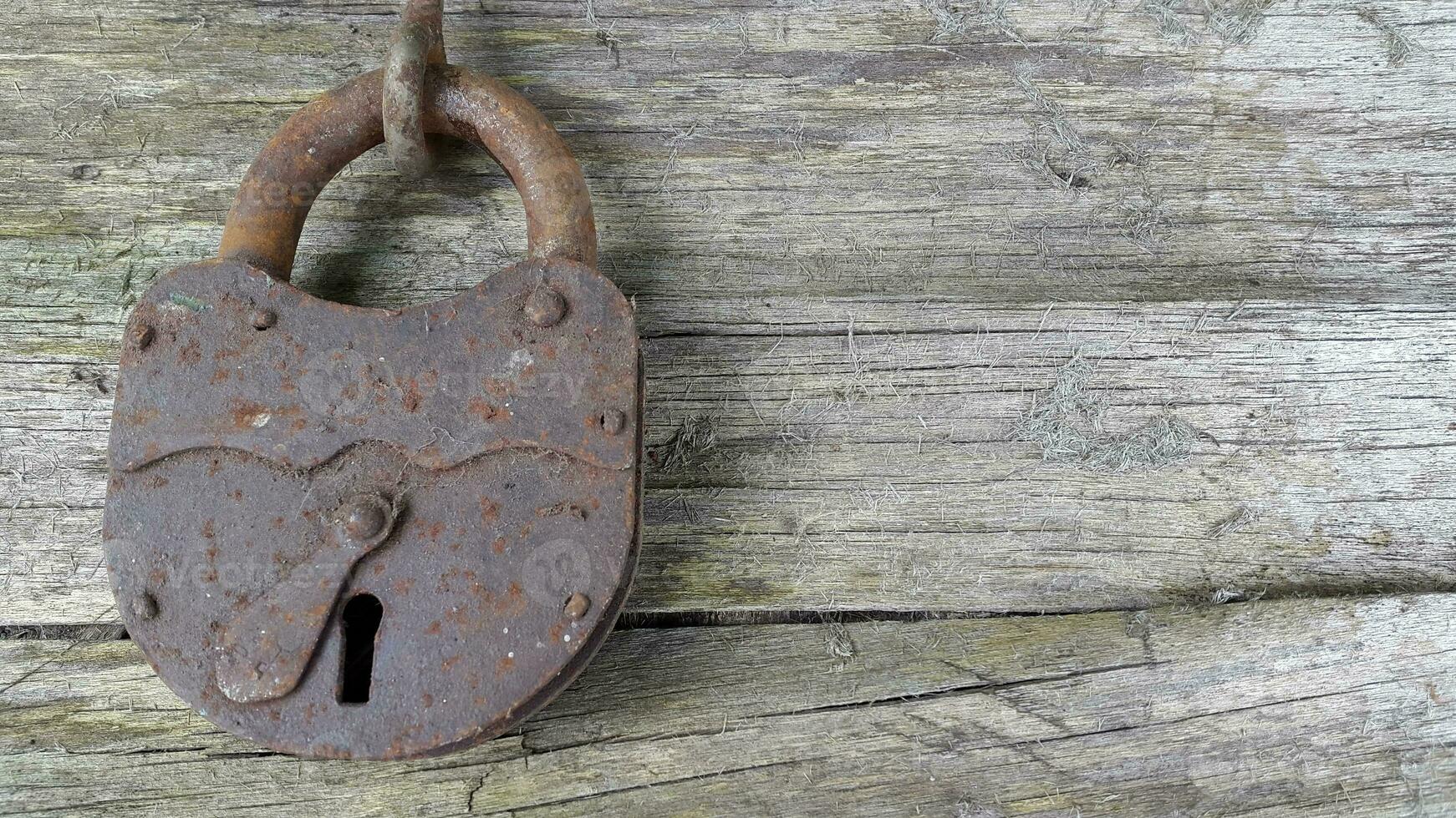 Old lock. Old padlock on a wooden background. Vintage photo