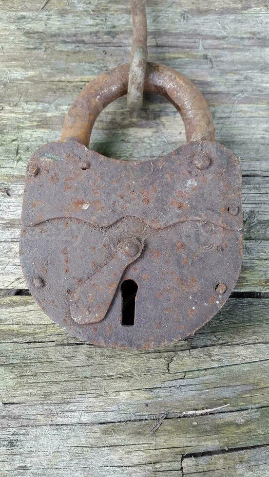 Old lock. Old padlock on a wooden background. Vintage photo