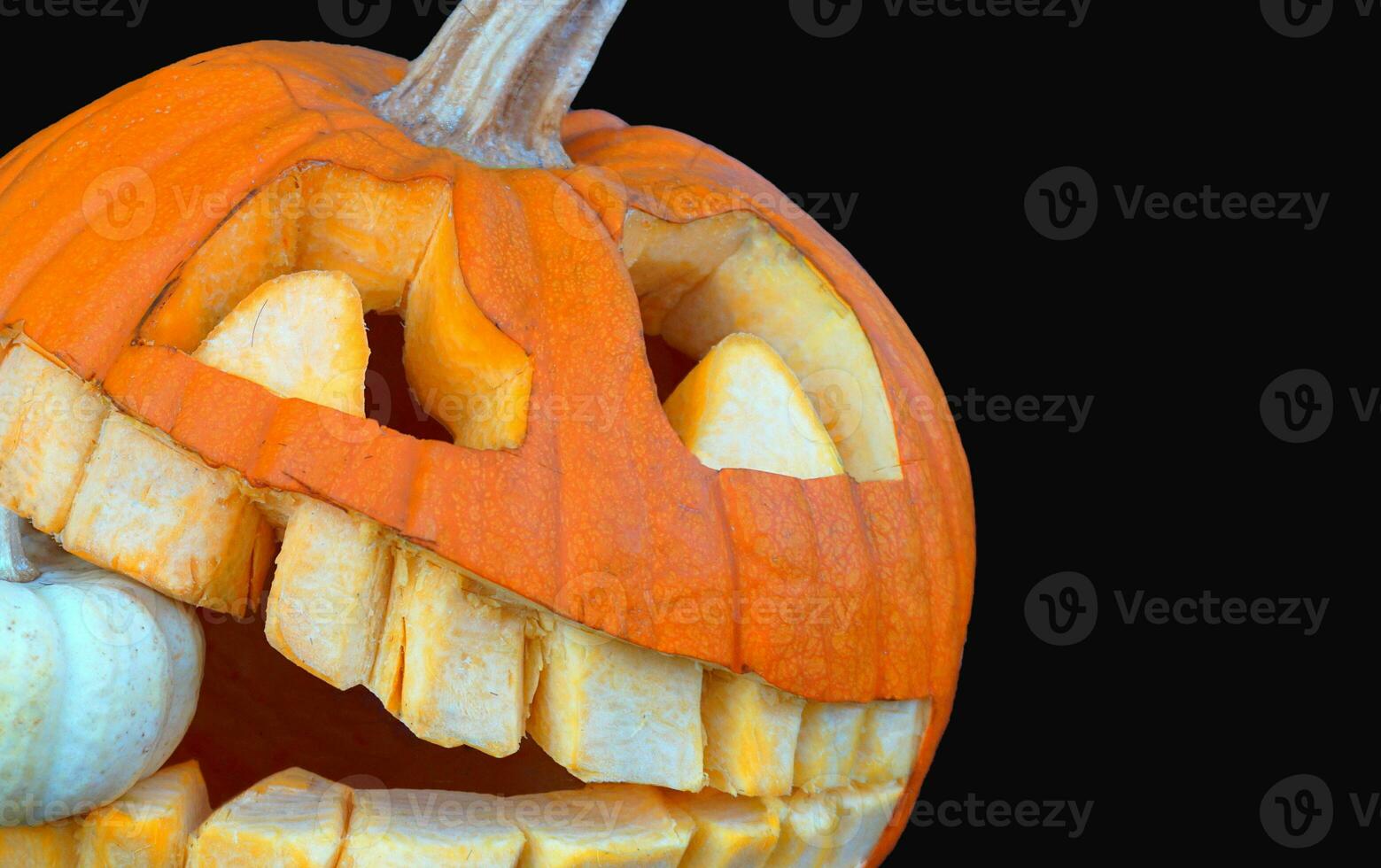 Spooky Carved Halloween Pumpkin on Eerie Black Background. Halloween and Black Friday Concepts photo