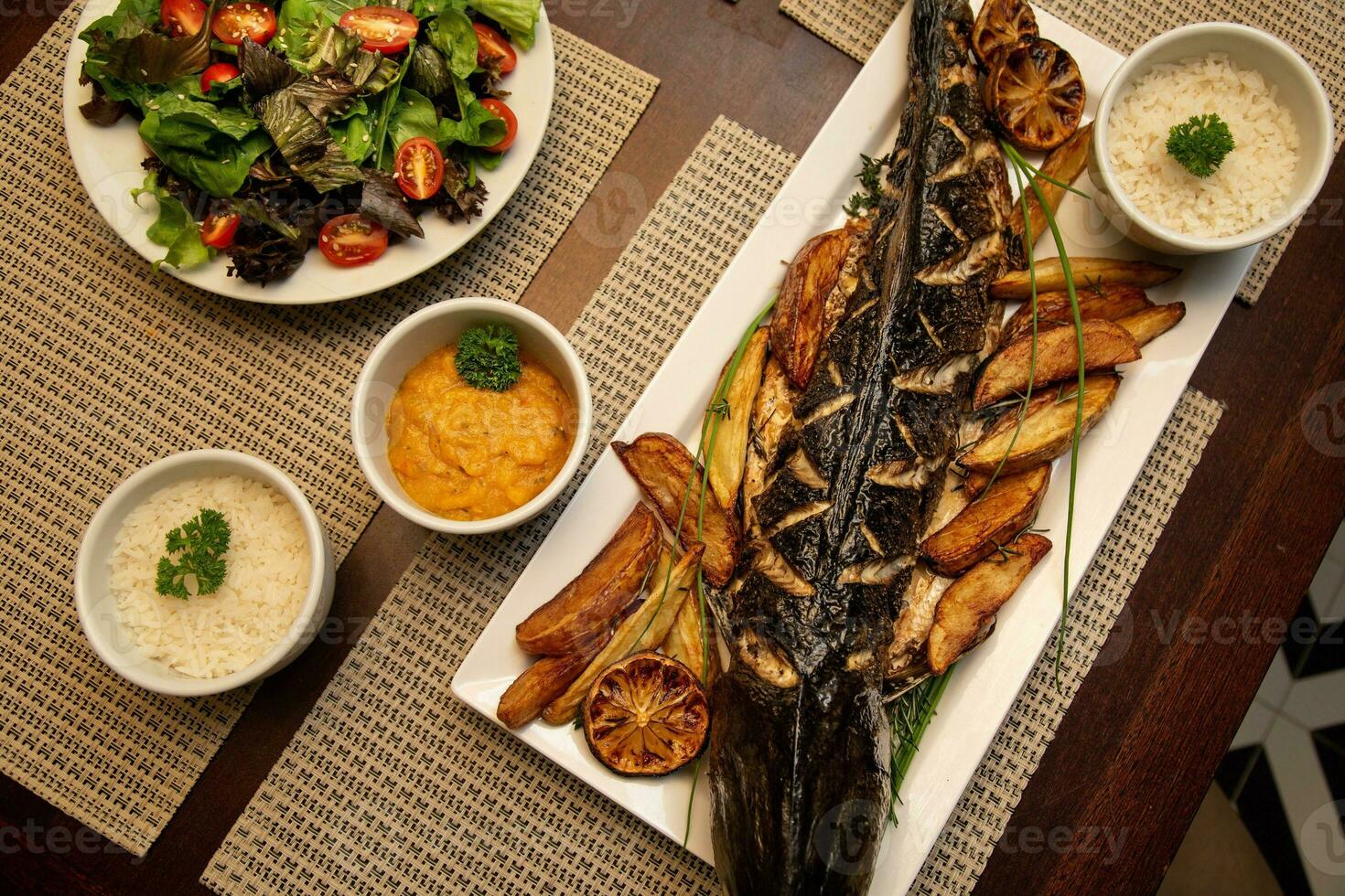 Fried mackerel fish with rice and vegetables on the table photo