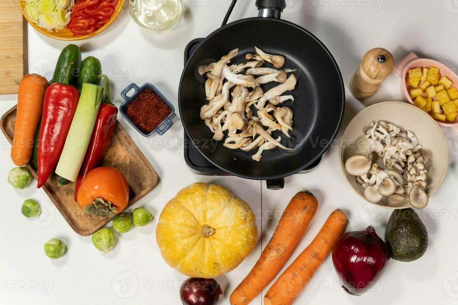 Vegetables and mushrooms in a frying pan on a white background photo