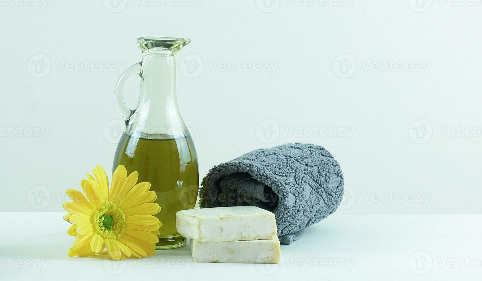 spa concepto - aceite, jabón, toalla y flor en blanco antecedentes foto