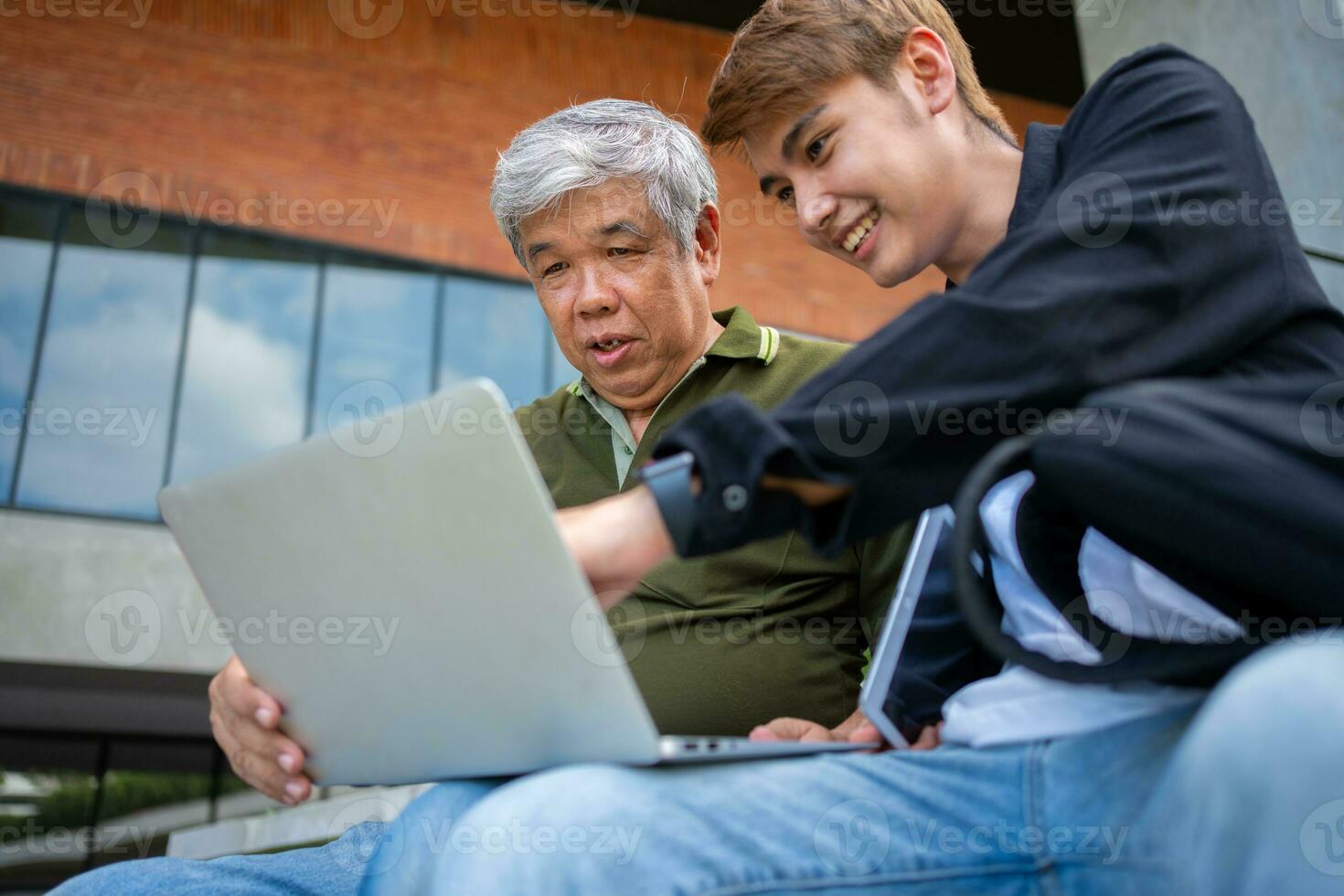 Focused young students listening old senior aged teachers for advise capstone project in university. Happy middle aged teacher working together with students for graduation project. photo