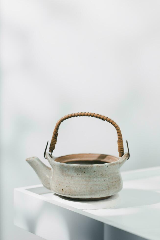 Japanese-style ceramic teapot on a white wooden table. photo