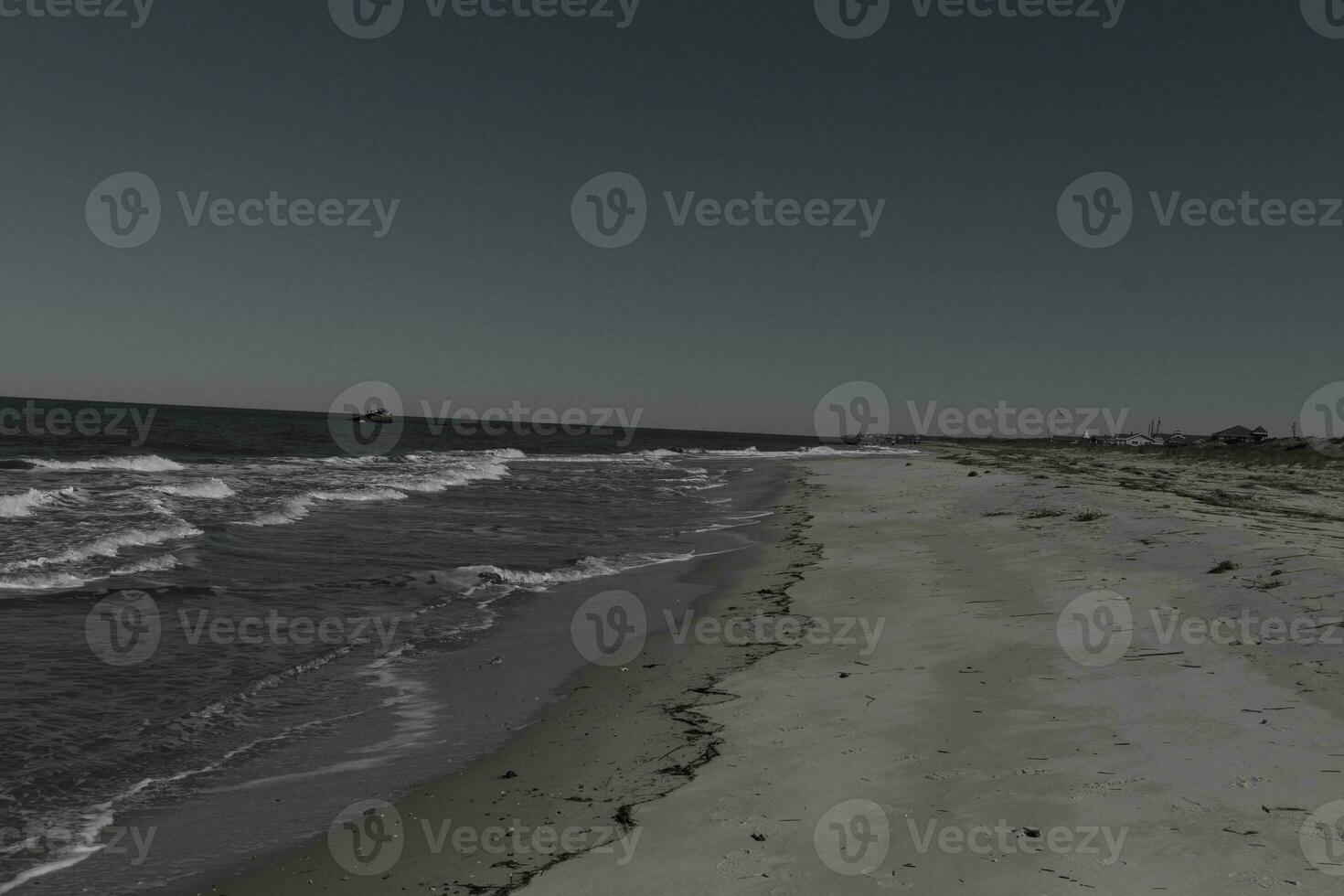 I loved the look of this beach scene as the waves crashed in. The pretty look of the whitecapped surd rushing in to the shore. The sand showing different tone to where the water once was. photo