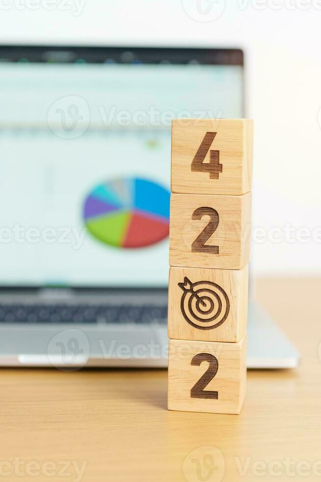 2024 Year block with dartboard icon against computer laptop background. Goal, Target, Resolution, strategy, plan, Action, mission, motivation, and New Year start concepts photo