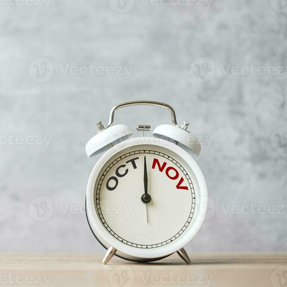 Hello November Changed from October month with vintage alarm clock on table background. Calendar, Monthly, New Start, Resolution, Goals, Plan, Action and Mission Concept photo