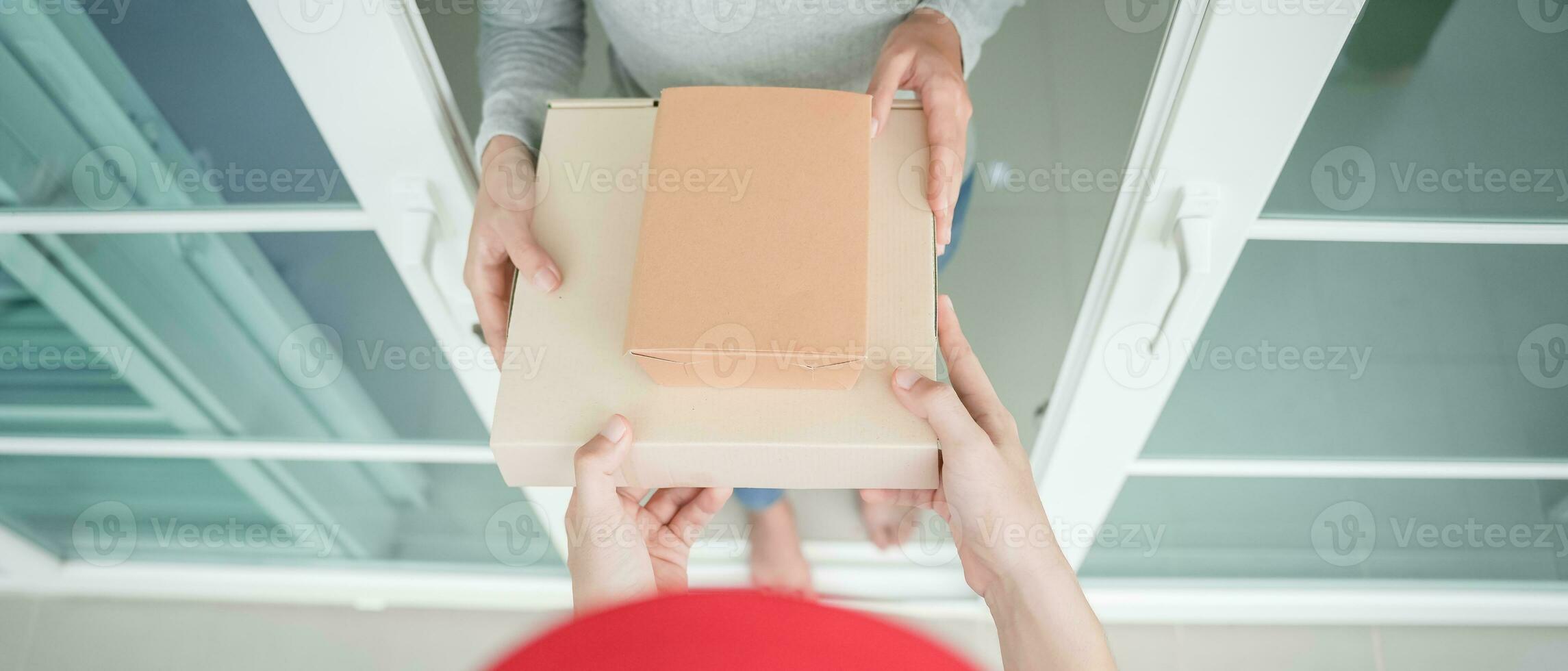 woman receives boxes parcel from courier in front house. Delivery man send deliver express. online shopping, paper containers, takeaway, postman, delivery service, packages photo