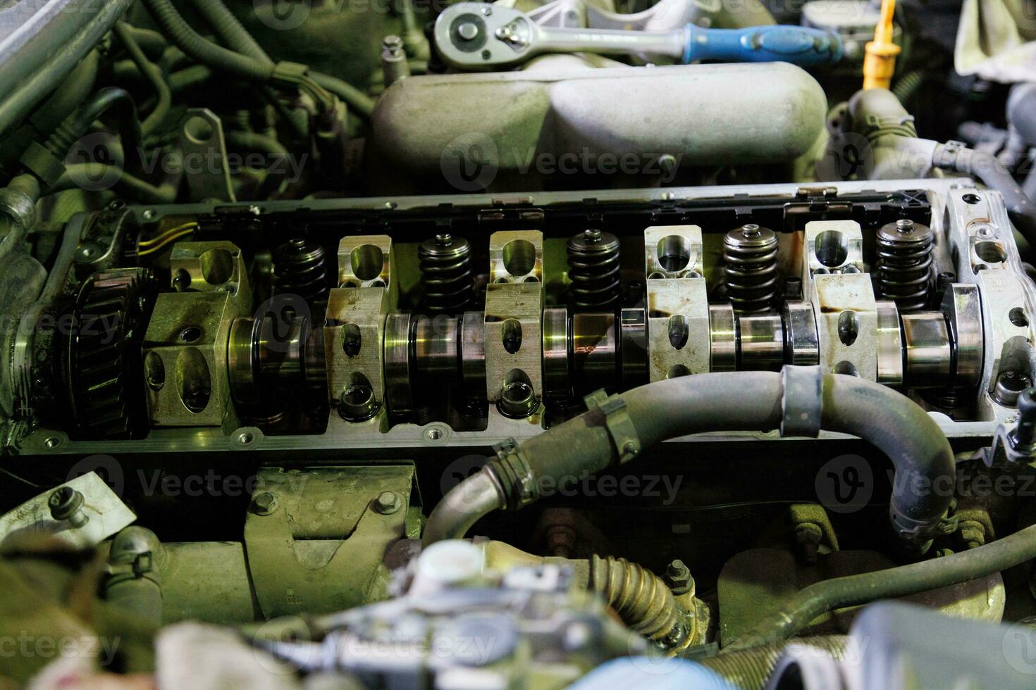 combustion engine of german SUV with removed valve cover and rocker arms shaft during motor repair process photo