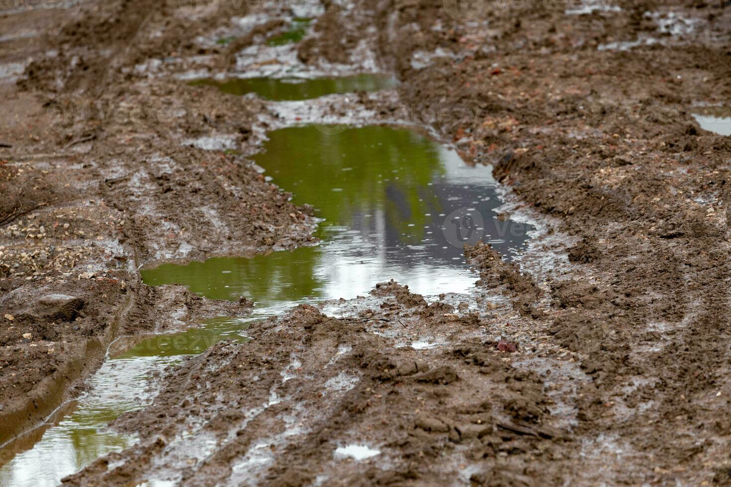 puddle in dirt road at summer day, closeup with selective focus photo