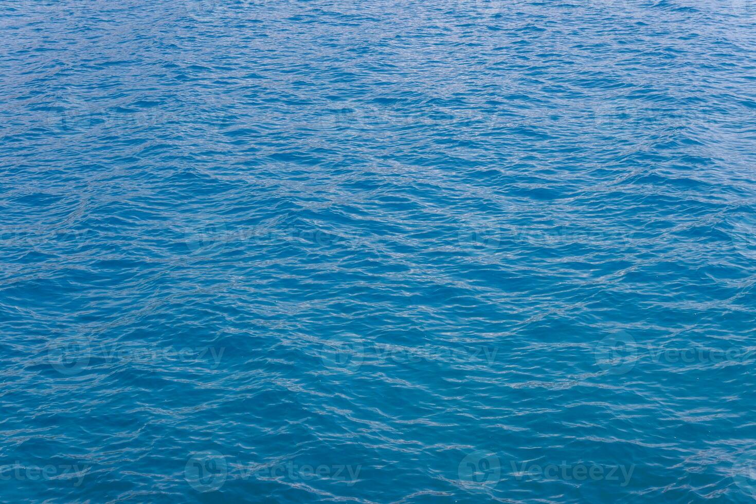 generic boundless sea water surface, only blue water at day time with mild ripple vawes photo