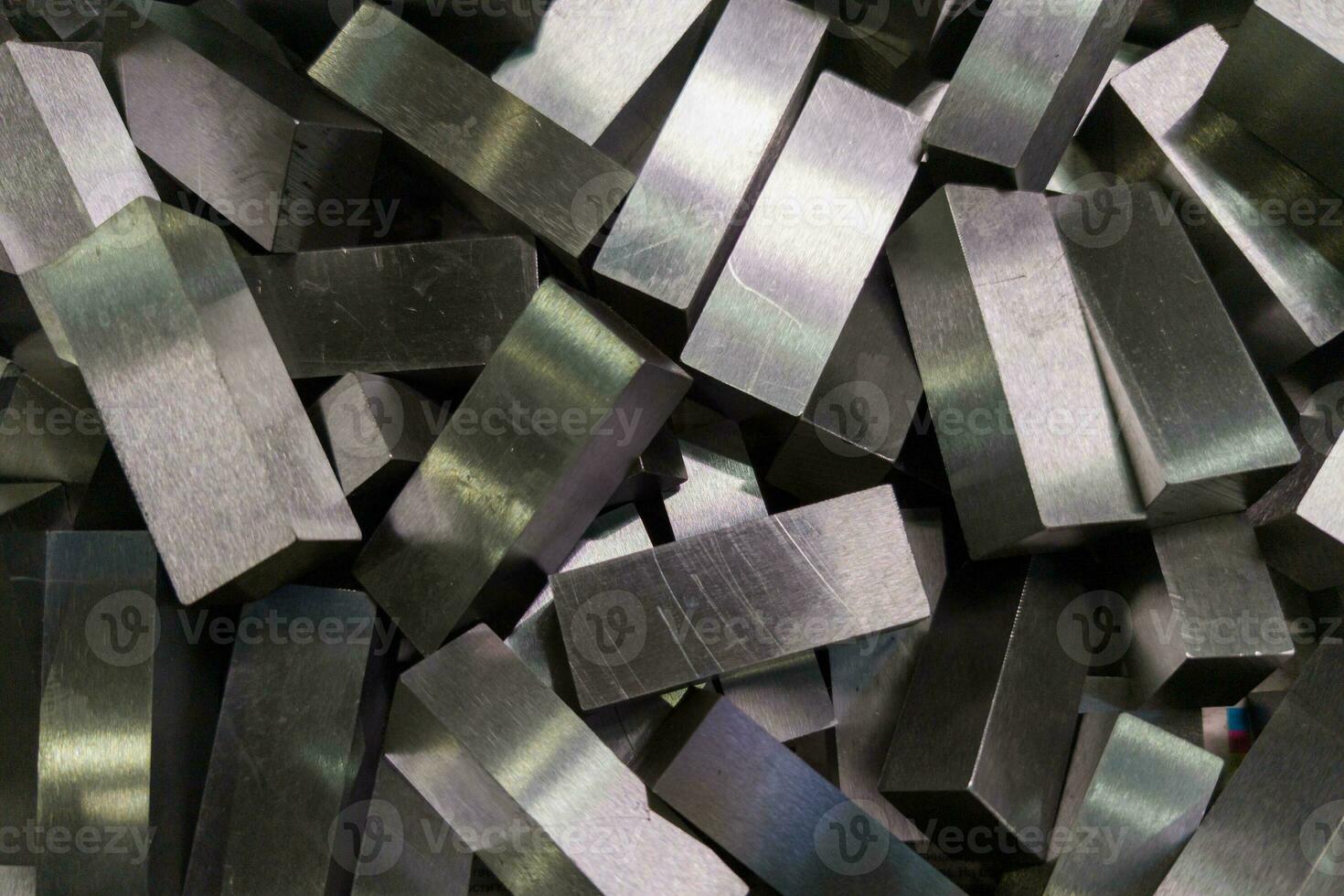 a pile of shiny faceted steel blocks - full frame close-up with selective focus photo
