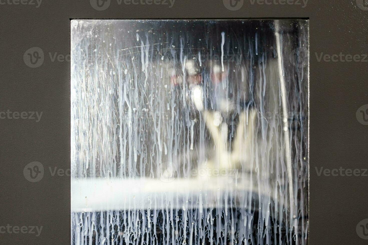 ventana rectangular de fresadora vertical abstracta cubierta con gotas de líquido refrigerante blanco y manchas foto