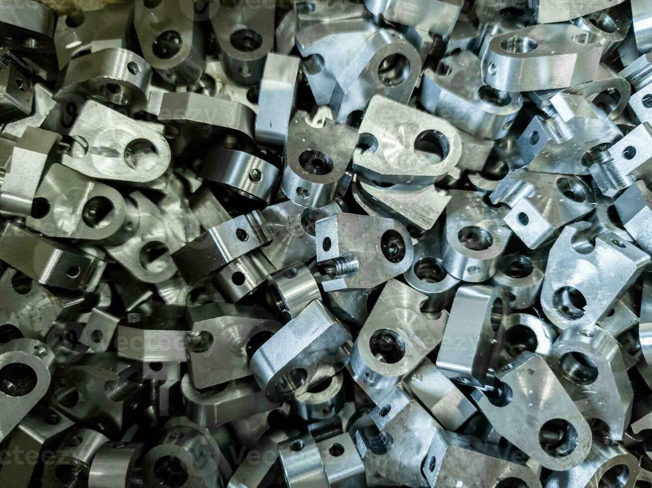 shiny steel parts background - heap of metal workpieces after milling and drilling operations photo