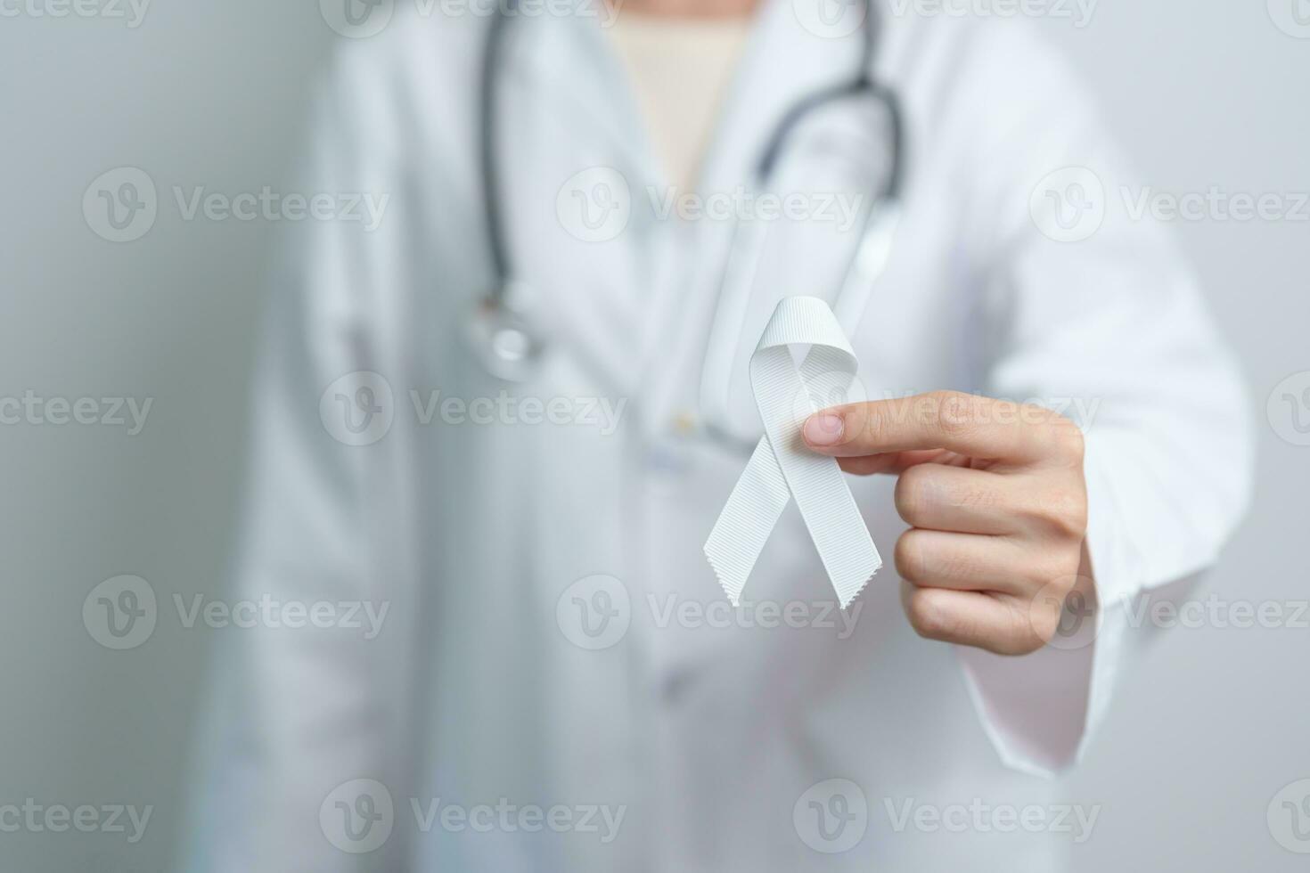 November Lung Cancer Awareness month. Doctor with White ribbon in hospital. Healthcare and World Cancer day concept photo