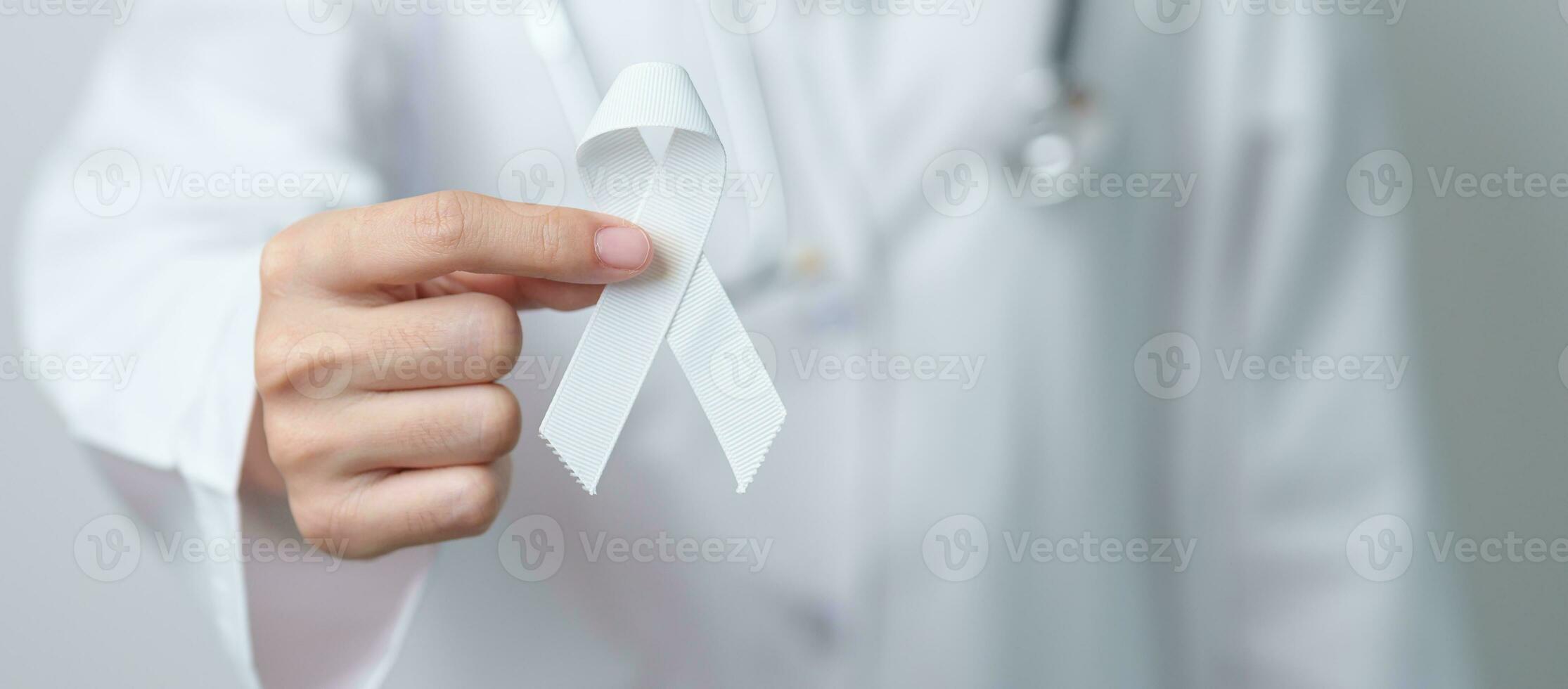 November Lung Cancer Awareness month. Doctor with White ribbon in hospital. Healthcare and World Cancer day concept photo