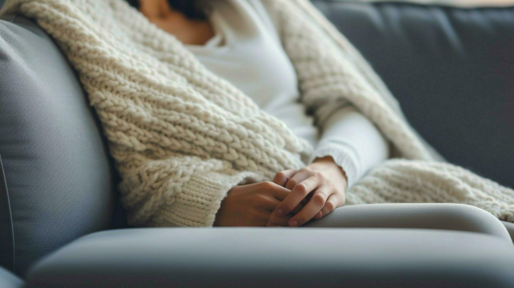cozy wool blanket on sofa hand holding pillow for relaxation photo