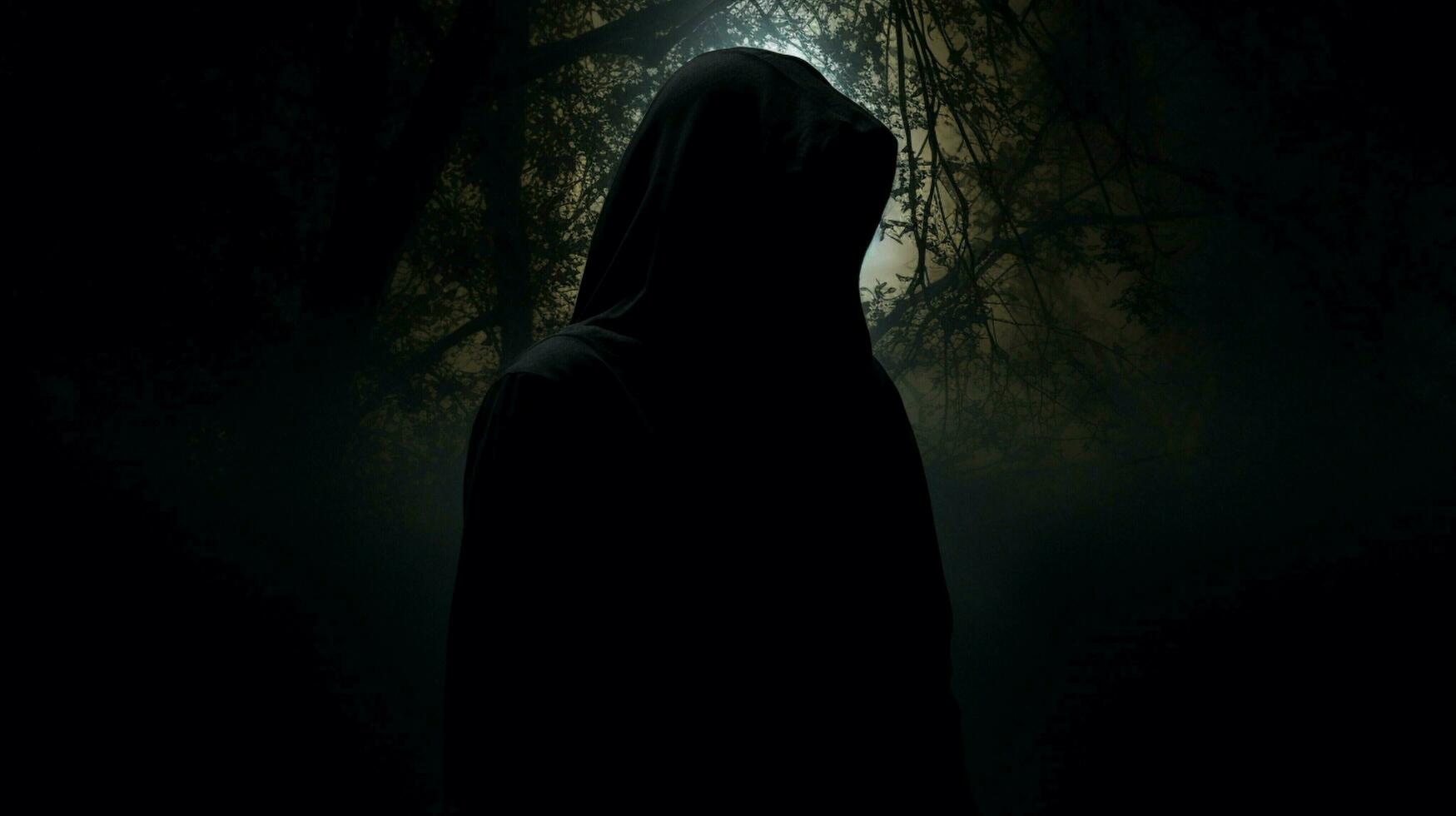 hooded silhouette in black spooky mystery revealed photo