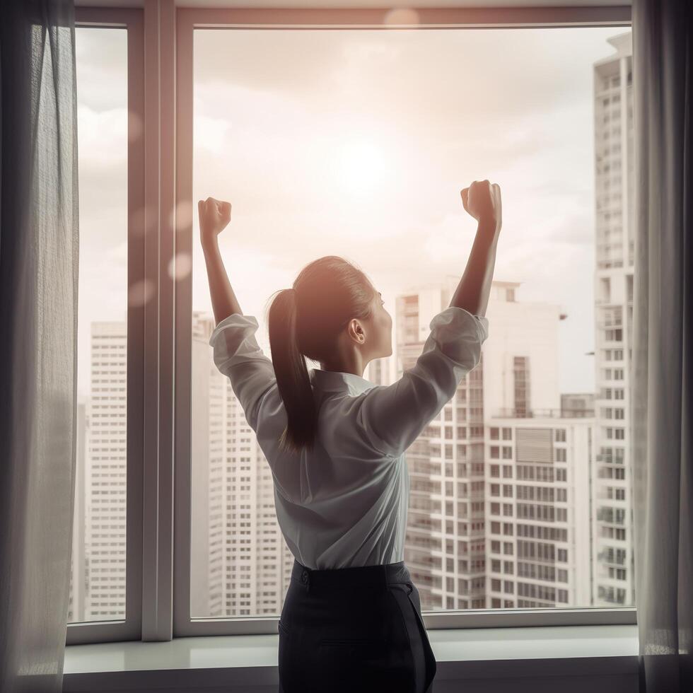 a woman is standing in front of a window with her arms up, photo