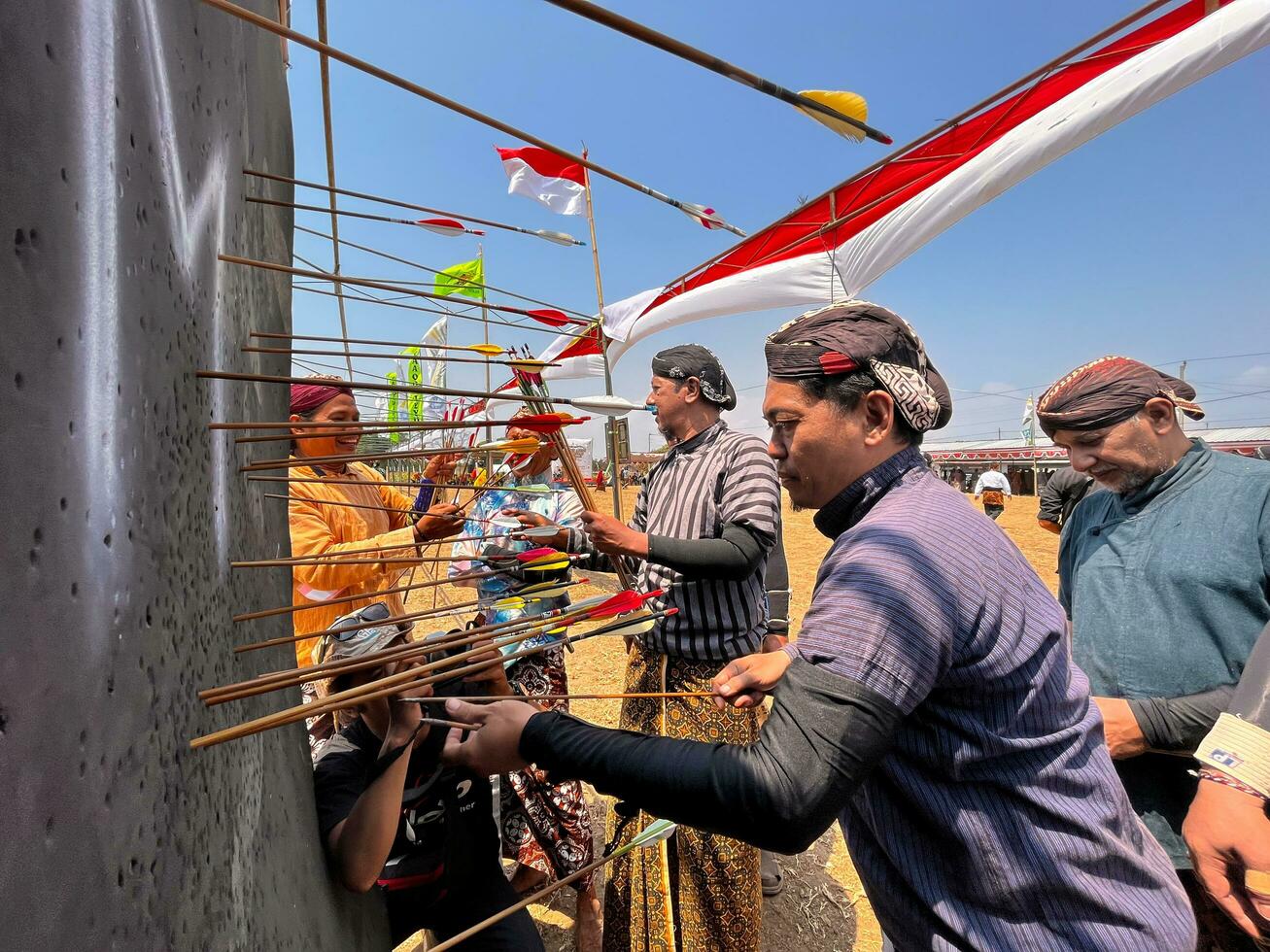 klaten, Indonesia, agosto 15, 2023. masculino y hembra Participantes, vestido en javanés personalizado tirado su arco por bizco a lograr concentración de objetivo exactitud en tradicional javanés flecha comercio. foto