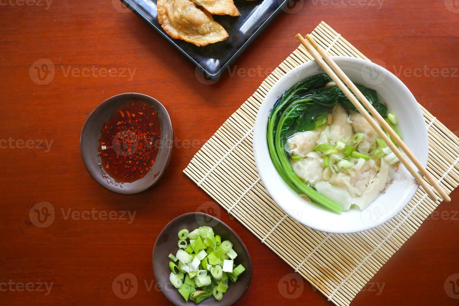 wonton soup. Bowl of wonton soup with chili oil. Shrimp or meat dumpling soup with mustard , green onions, photo